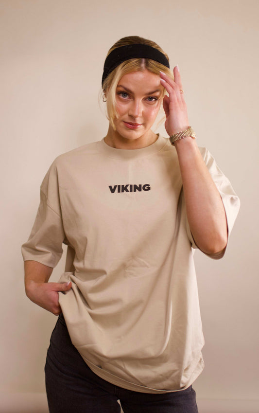 Apricot Viking t-shirt with black text logo, worn by woman with black headband and watch