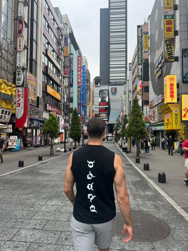 Man wearing black Viking Tank Top with white Viking symbols walking in urban street