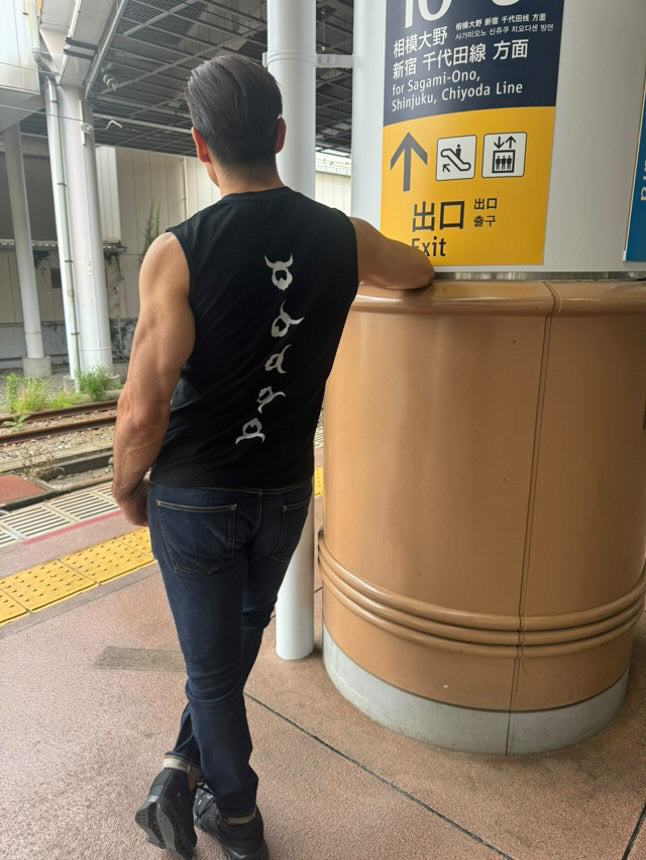 Man wearing black Viking Tank Top with white vertical Viking design at train station platform