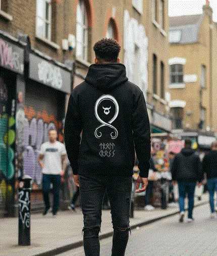 Man wearing black Viking Protection Symbol Hoodie with iconic white symbol on back walking in urban street setting